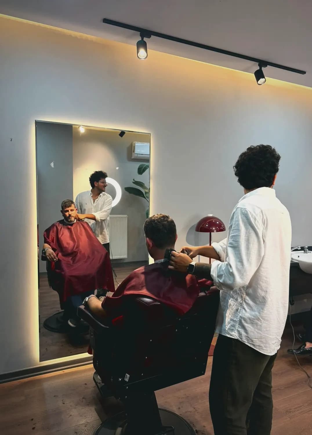 Rain Barber Studio'da ayna karşısında saç kesimi yapılırken